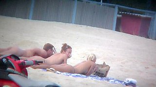 Beach spy captures two friends sunbathing topless