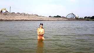 Naked girl masturbates on the river shore