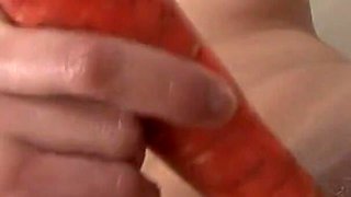 Sexy redhead fucks her ass and pussy with two huge carrots