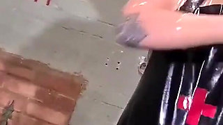 Latex Nurse inspects her gimp patient