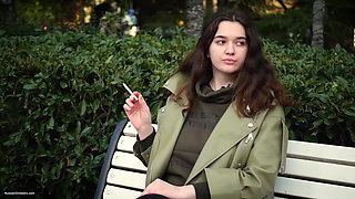 Young Brunette Is Taking an Unhurried Stroll with Allwhite 120mm Cigarette